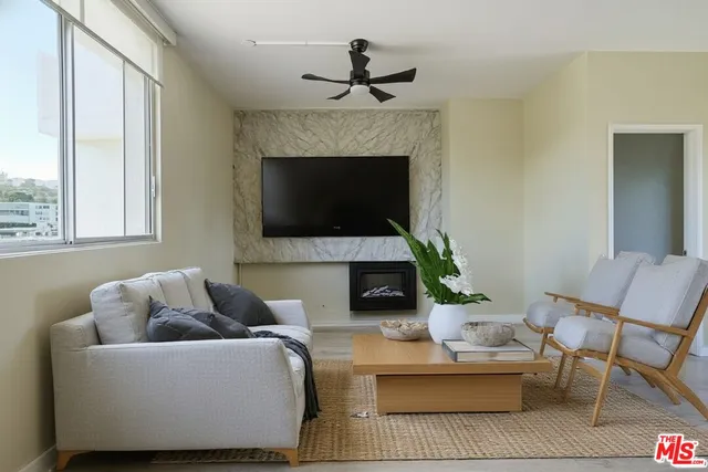 a living room with furniture a fireplace and a flat screen tv