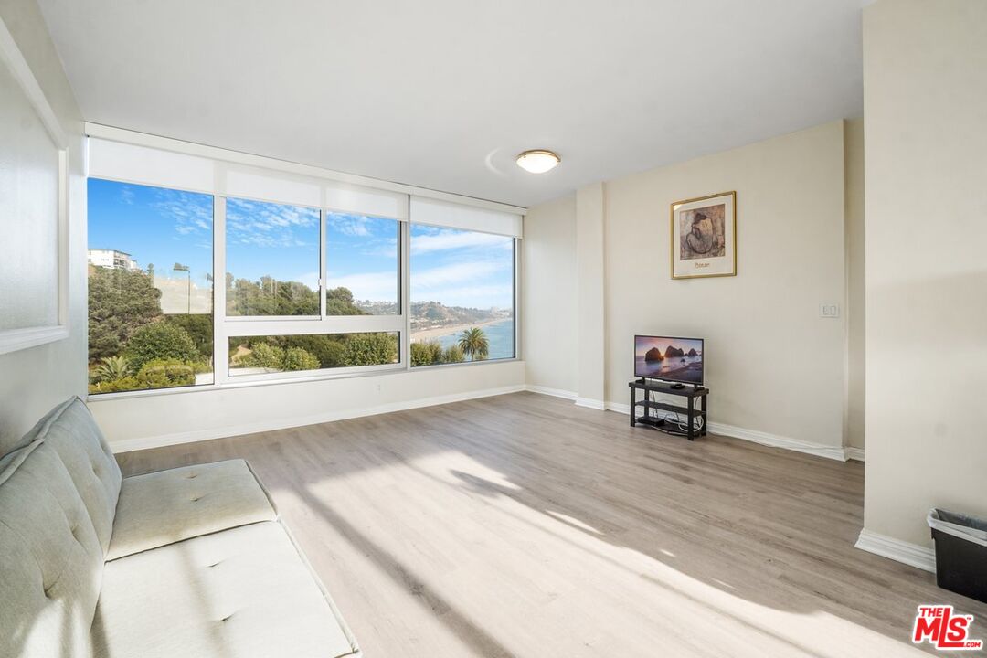 17350 Sunset Boulevard, Unit PH2 Pacific Palisades, CA 90272 - Photo 7 of 36 a view of a room with a large window and a wooden floor