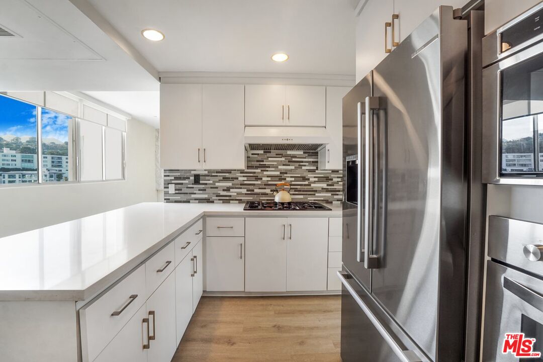 17350 Sunset Boulevard, Unit PH2 Pacific Palisades, CA 90272 - Photo 8 of 36 a kitchen with stainless steel appliances granite countertop a refrigerator and a sink
