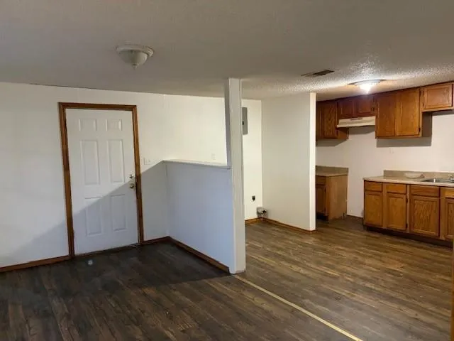 a view of a kitchen with wooden floor and a sink