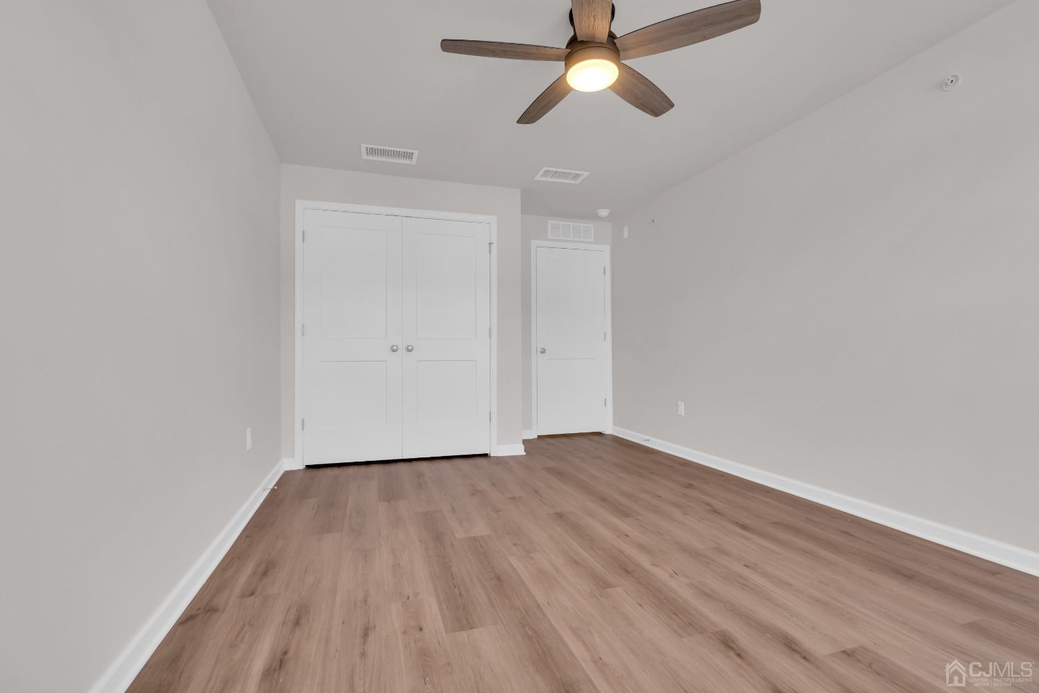 75 Depot Way Dunellen, NJ 08812 - Photo 23 of 28 an empty room with wooden floor ceiling fan and windows