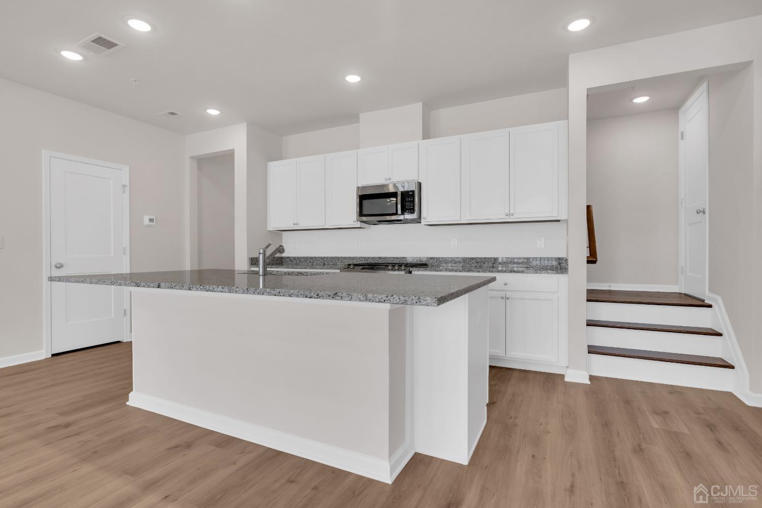 75 Depot Way Dunellen, NJ 08812 - Photo 6 of 28 a kitchen with granite countertop white cabinets and stainless steel appliances