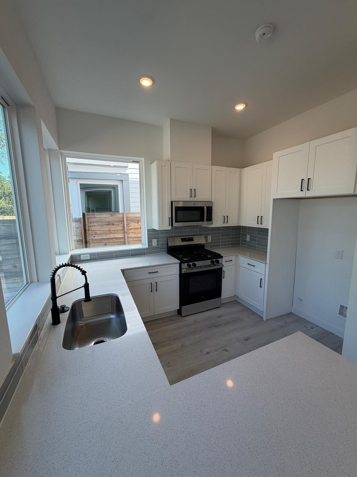 2000 Riverside Farms Road, Unit 12101 Austin, TX 78741 - Photo 11 of 33 Luminous kitchen features sleek stone countertops, modern cabinetry, and recessed lighting over wood floors.