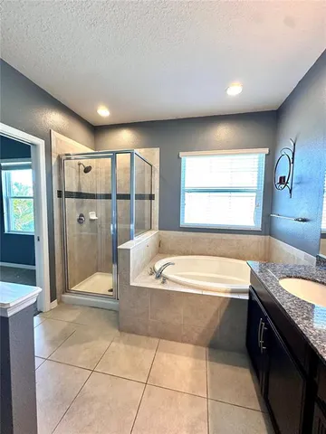 a spacious bathroom with a tub sink and shower