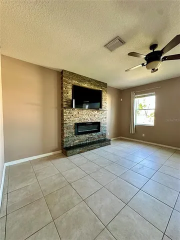 a view of an empty room with a fireplace and a window