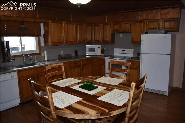 a kitchen with a refrigerator a stove a sink dishwasher and wooden cabinets with wooden floor
