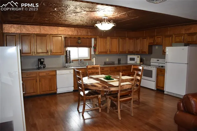 a kitchen with a table chairs refrigerator and cabinets