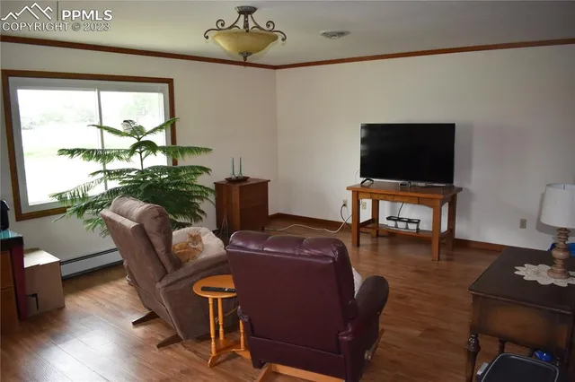 a living room with furniture a flat screen tv and wooden floor