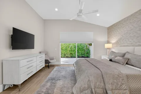 a spacious bedroom with a bed a mirror and lamp