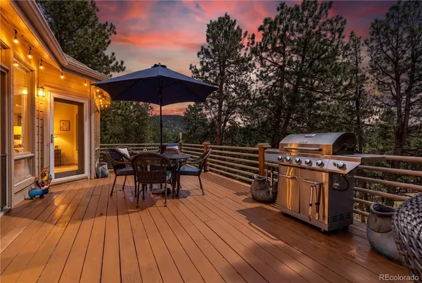 a view of a chairs and table on the wooden roof deck