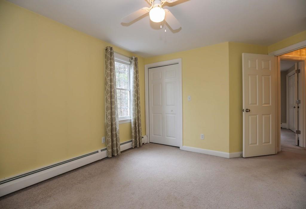 323 Sugar Road Bolton, MA 01740 - Photo 23 of 35 an empty room with a chandelier fan and windows