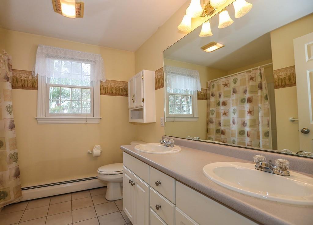 323 Sugar Road Bolton, MA 01740 - Photo 25 of 35 a bathroom with a double vanity sink toilet and a mirror