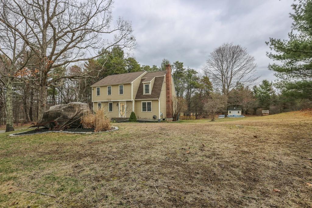 323 Sugar Road Bolton, MA 01740 - Photo 3 of 35 a front view of a house with a yard and garage