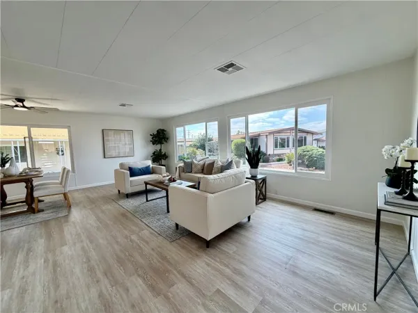 a spacious bedroom with a bed a chandelier and windows