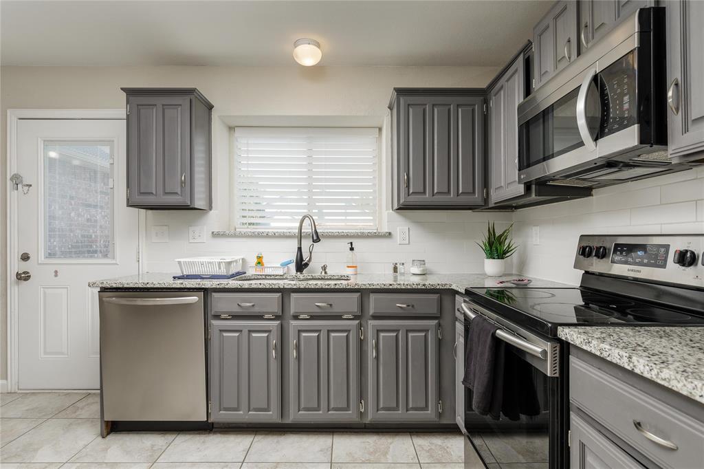 4108 Fryer Street The Colony, TX 75056 - Photo 12 of 27 a kitchen with stainless steel appliances granite countertop a sink a stove microwave and cabinets