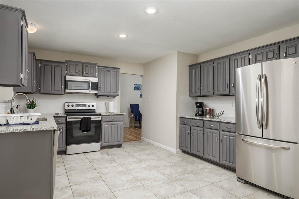 4108 Fryer Street The Colony, TX 75056 - Photo 13 of 27 a kitchen with a stove top oven a sink dishwasher and a refrigerator