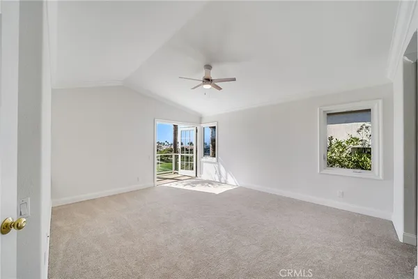 an empty room with windows and ceiling fan