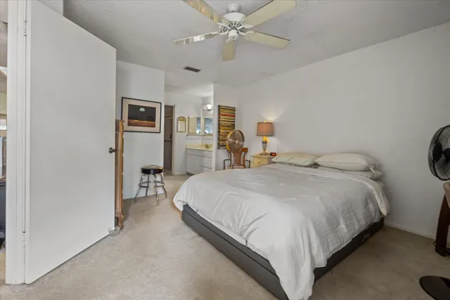 a spacious bedroom with a bed and a chandelier