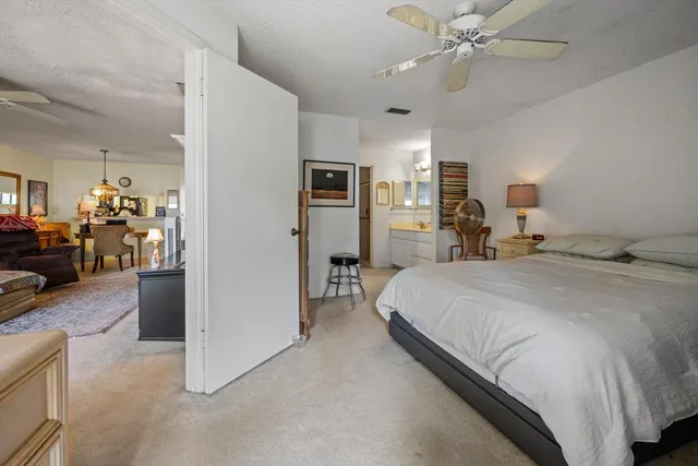 a spacious bedroom with a bed and ceiling fan