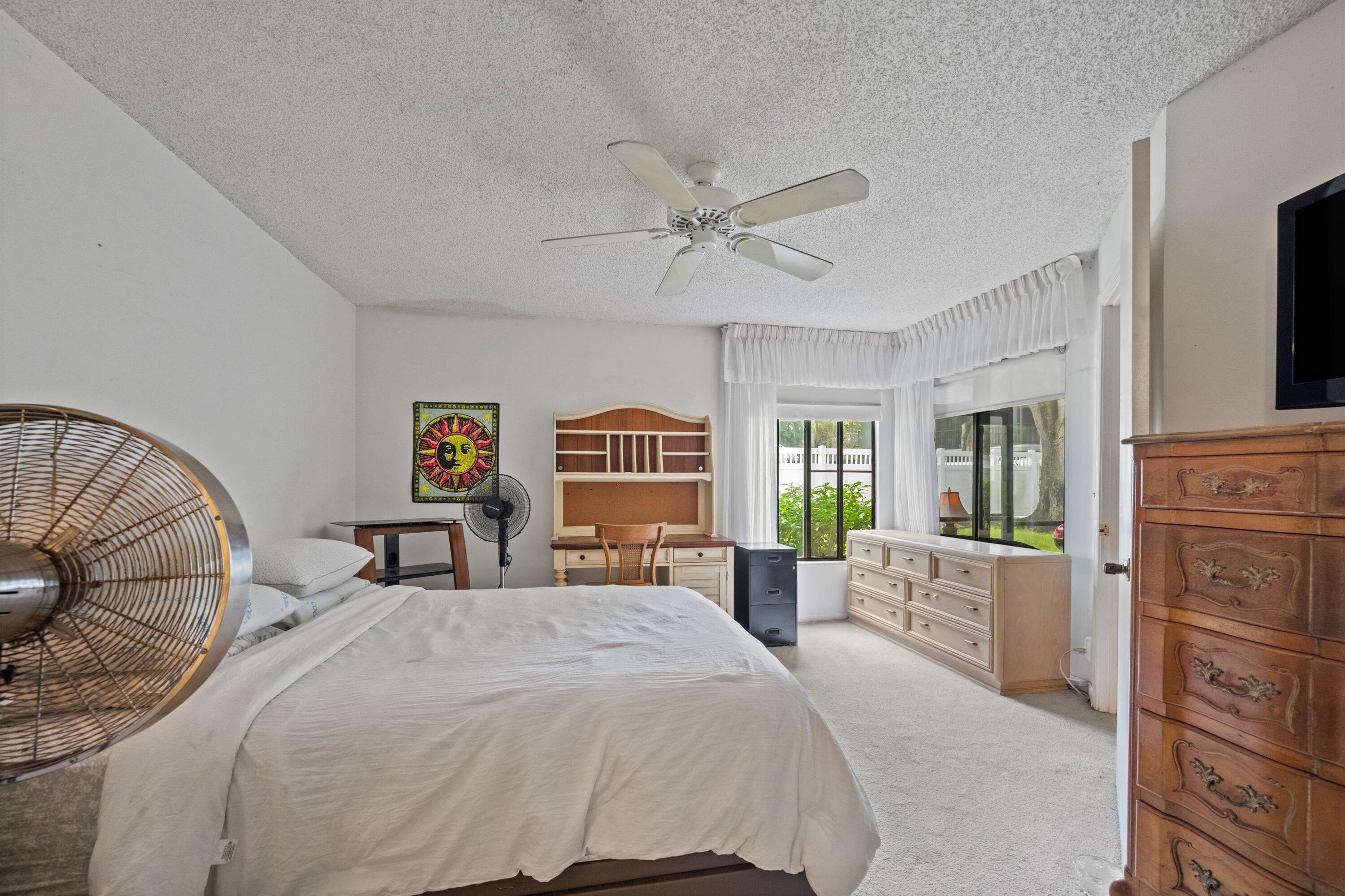 103 Harbour Pointe Way Greenacres, FL 33413 - Photo 17 of 32 a bedroom with a large bed and a chandelier