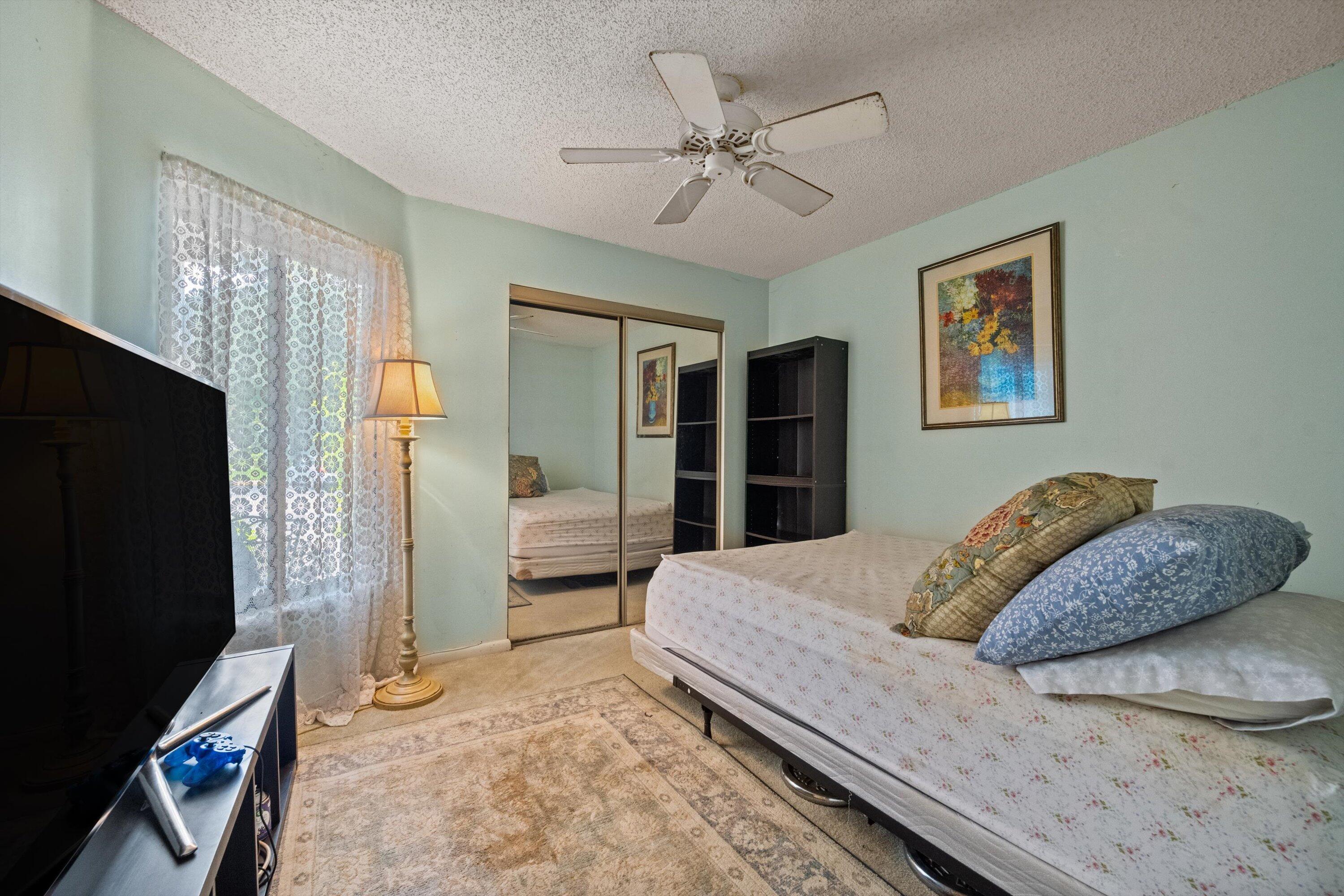 103 Harbour Pointe Way Greenacres, FL 33413 - Photo 19 of 32 a bedroom with a bed and a flat screen television