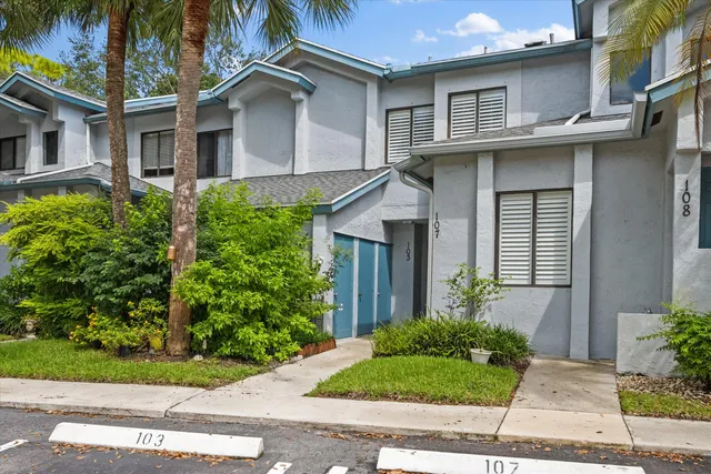a view of a white house next to a yard