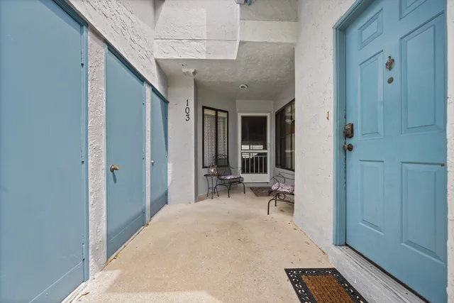 a view of a hallway with wooden floor and furniture