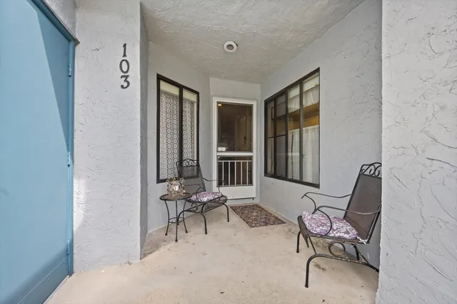 a living room with furniture and two windows