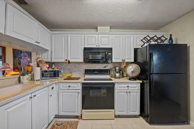 a kitchen with stainless steel appliances granite countertop a refrigerator stove and sink
