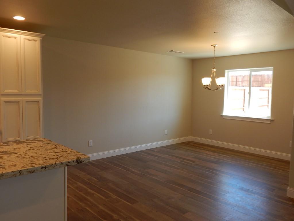 11341 Puffin Way Redding, CA 96003 - Photo 7 of 25 an empty room with wooden floor and windows