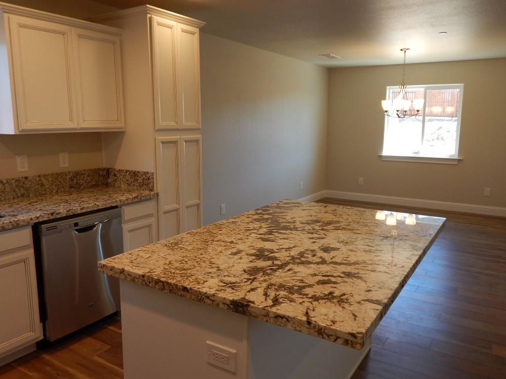 11341 Puffin Way Redding, CA 96003 - Photo 8 of 25 a view of kitchen island a sink wooden floor and cabinets