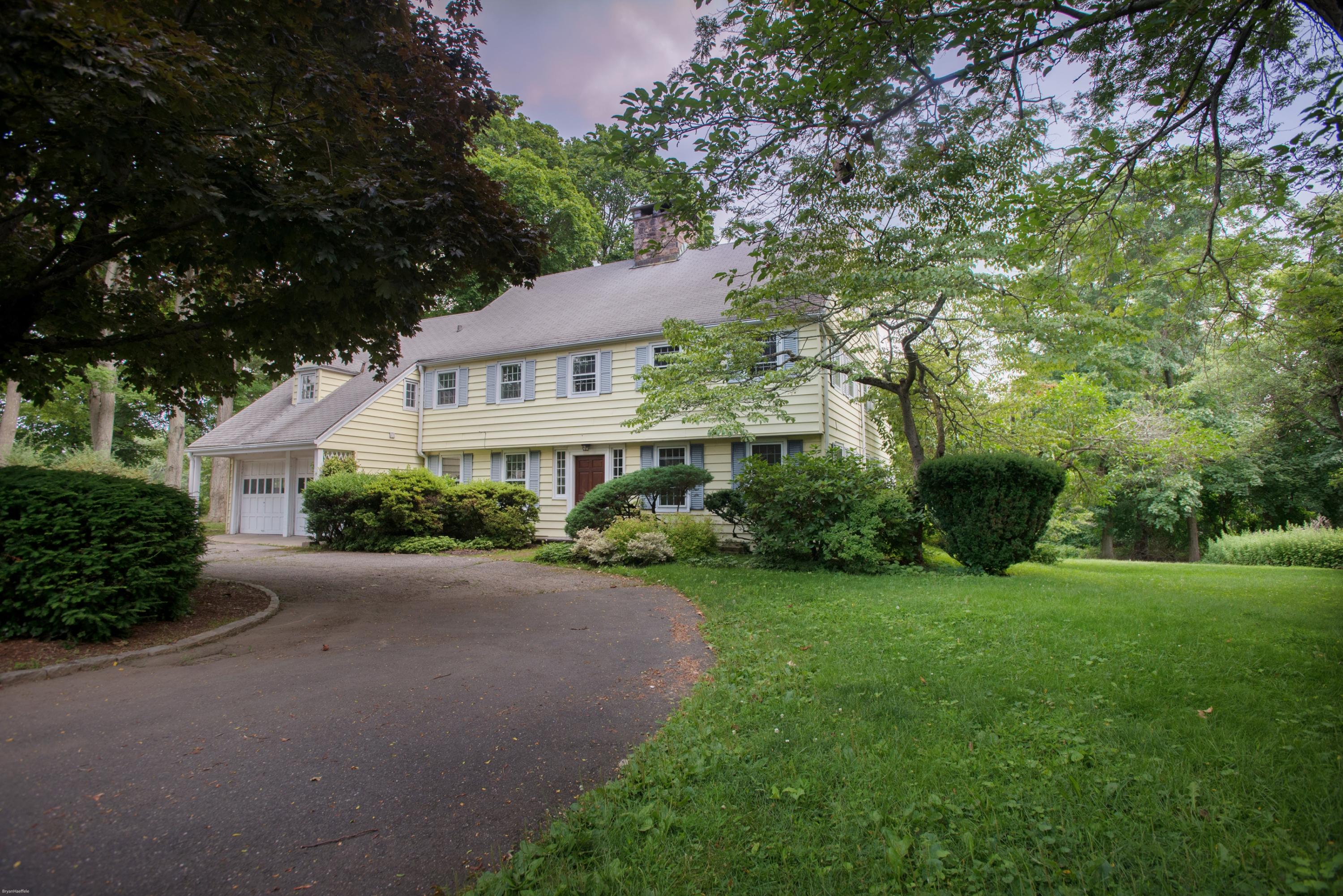 a front view of a house with yard and green space