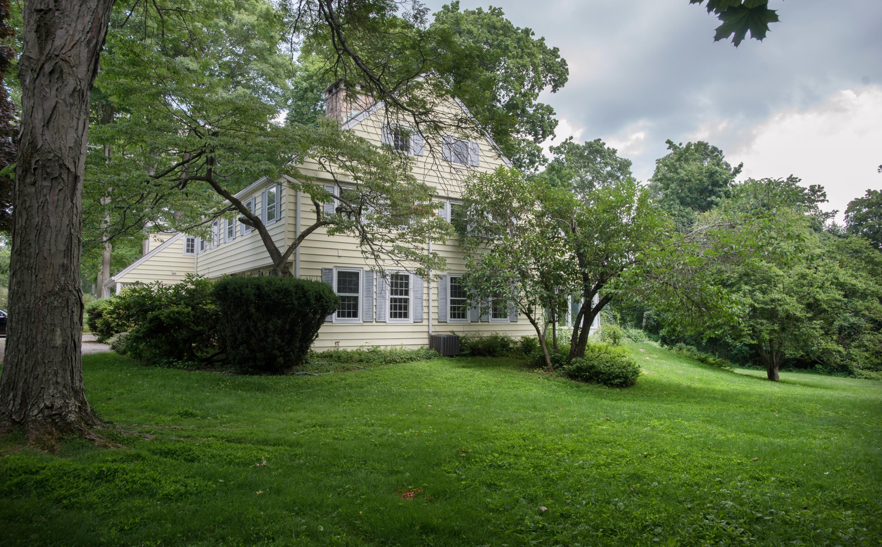 65 Oenoke Ridge New Canaan, CT 06840 - Photo 18 of 22 a view of house in front of a big yard with large trees