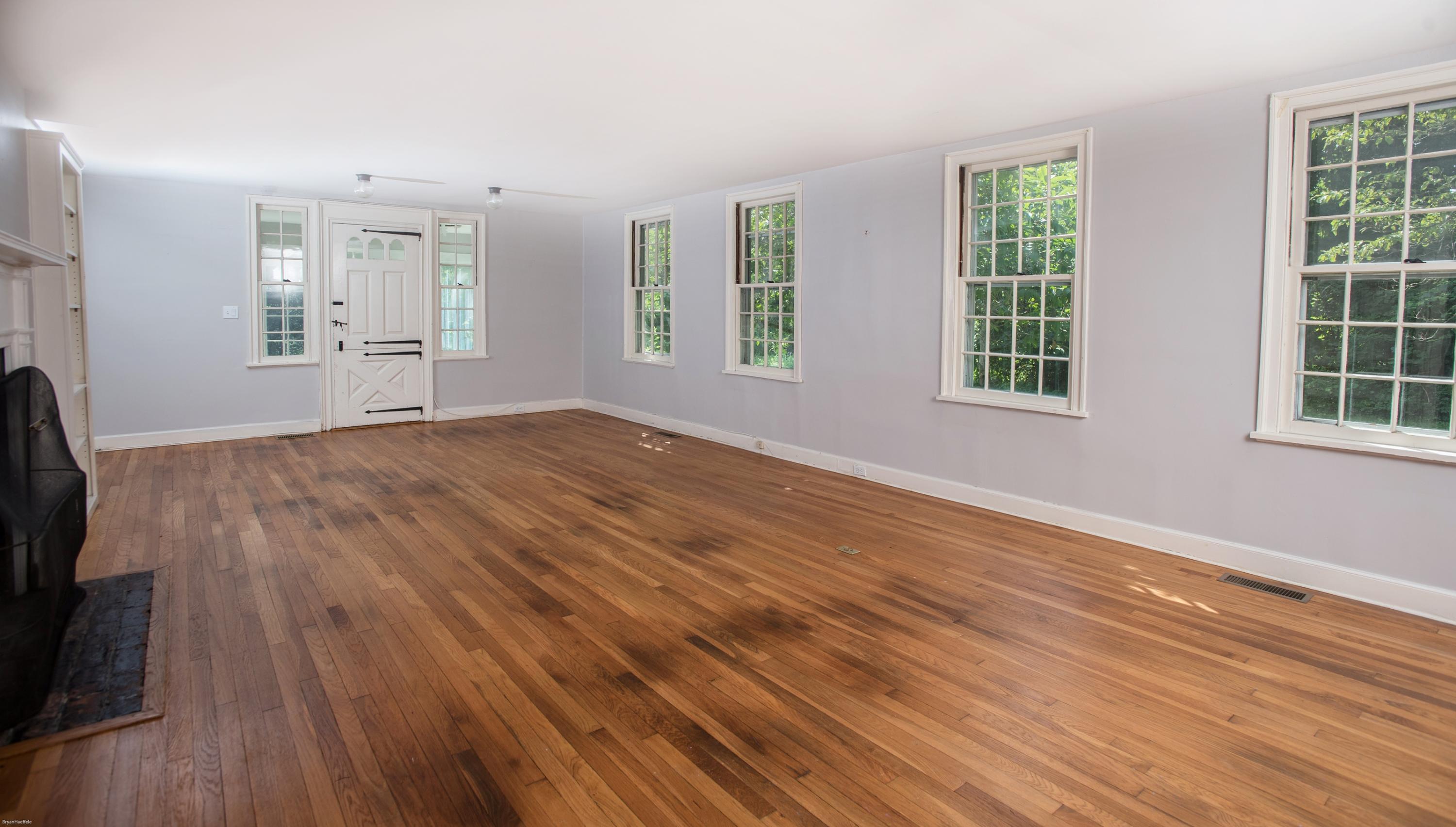 65 Oenoke Ridge New Canaan, CT 06840 - Photo 3 of 22 an empty room with wooden floor and windows