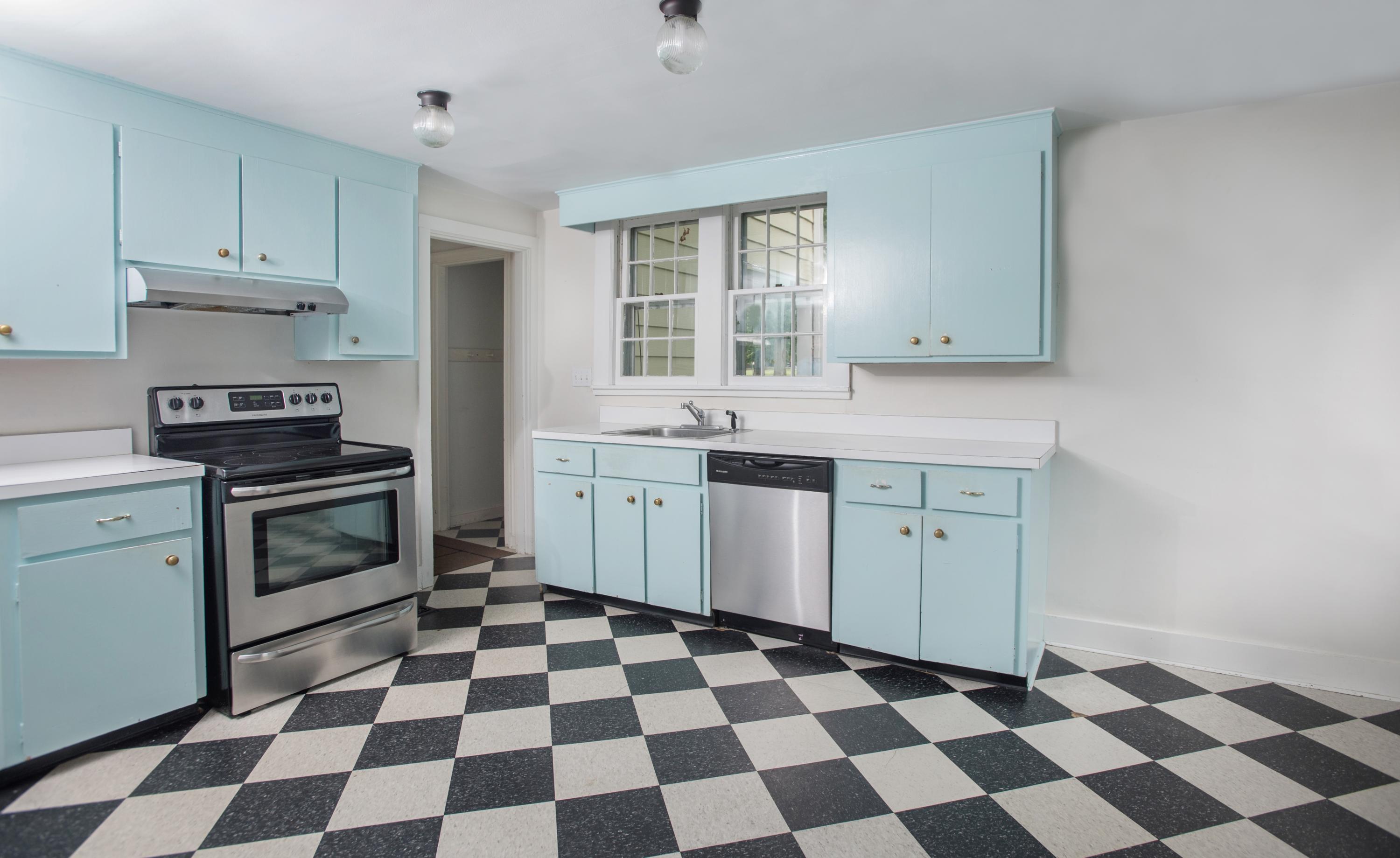65 Oenoke Ridge New Canaan, CT 06840 - Photo 7 of 22 a kitchen with a checkered floor and white cabinets