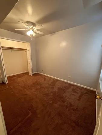 en empty room with windows and ceiling fan