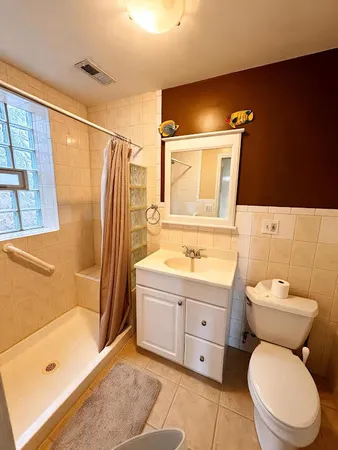 a bathroom with a granite countertop toilet sink and mirror