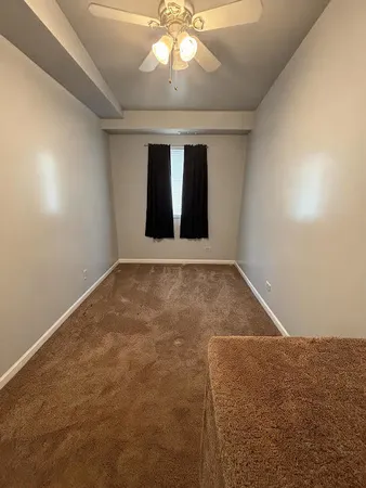en empty room with windows and ceiling fan
