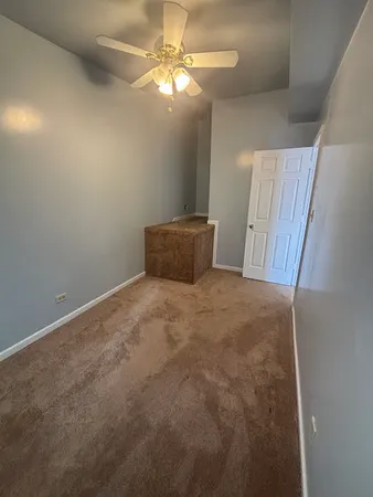a view of an empty room with a chandelier fan