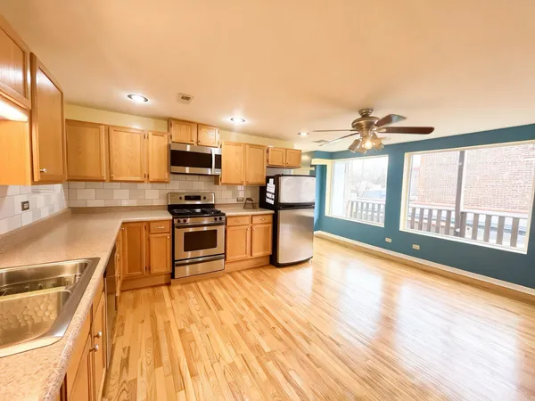 a kitchen with stainless steel appliances a stove top oven a sink and a microwave