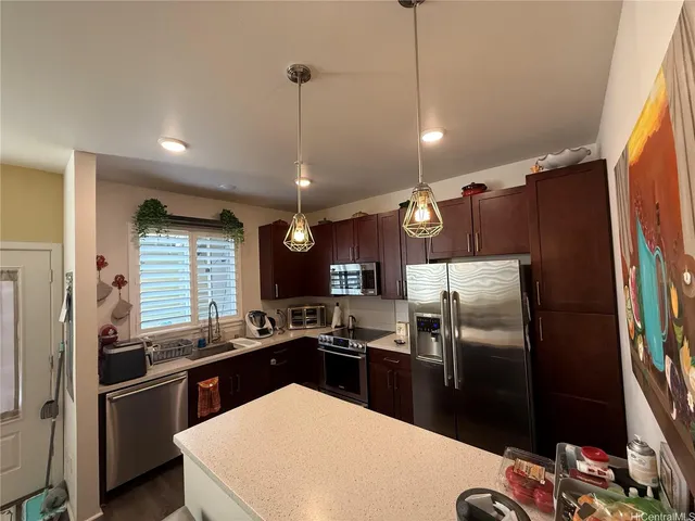 a kitchen with granite countertop a refrigerator and a sink