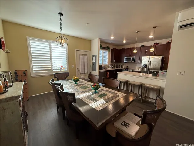 a view of a dining room and livingroom with furniture wooden floor a chandelier