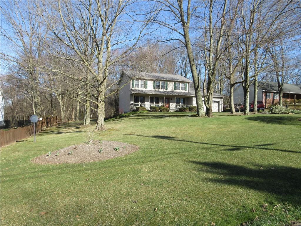 a view of a building with a big yard and large trees