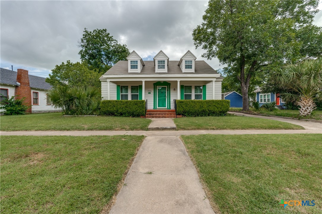 a front view of a house with a garden