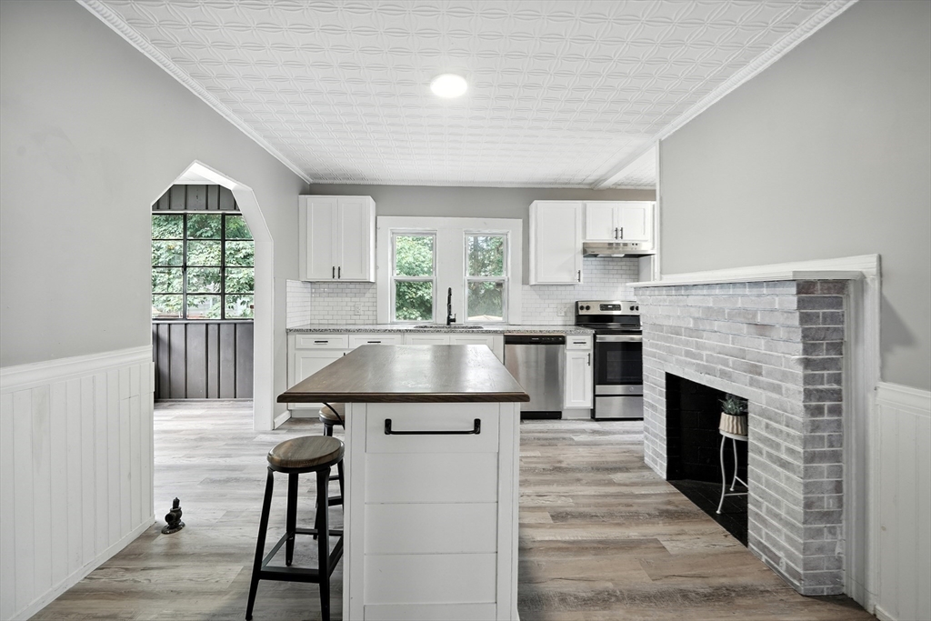 30 Beauchamp Street Springfield, MA 01107 - Photo 7 of 30 a kitchen with kitchen island wooden cabinets and a fireplace