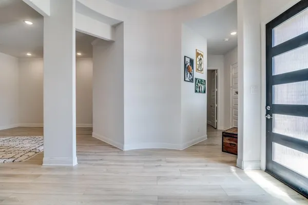 a view of a hallway with wooden floor and closet