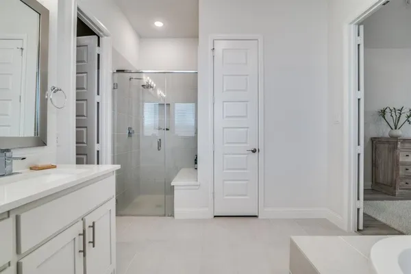 a spacious bathroom with a shower sink and mirror