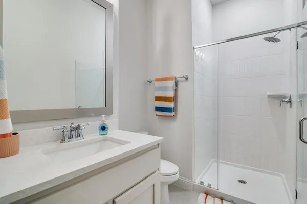 a bathroom with a granite countertop sink toilet and shower
