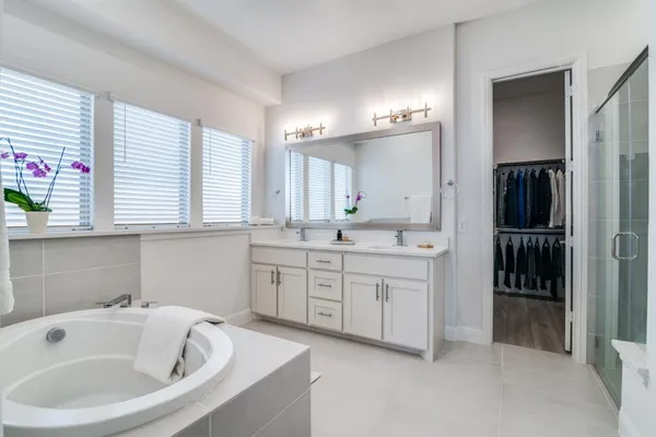 a bathroom with a tub sink and mirror