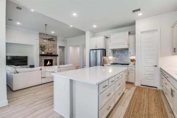 a large white kitchen with cabinets a sink and a stove